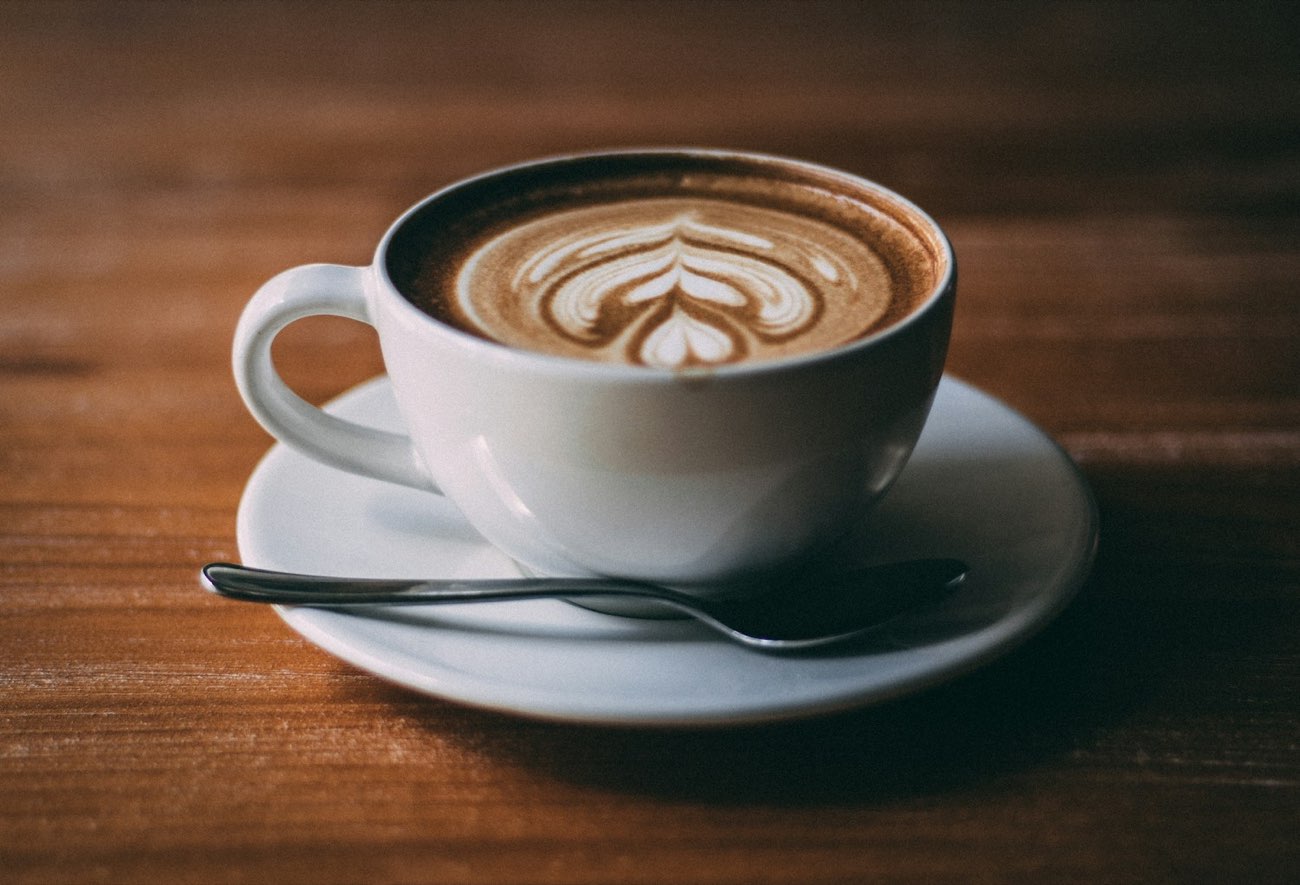 A cappuccino with latte art on a wooden table